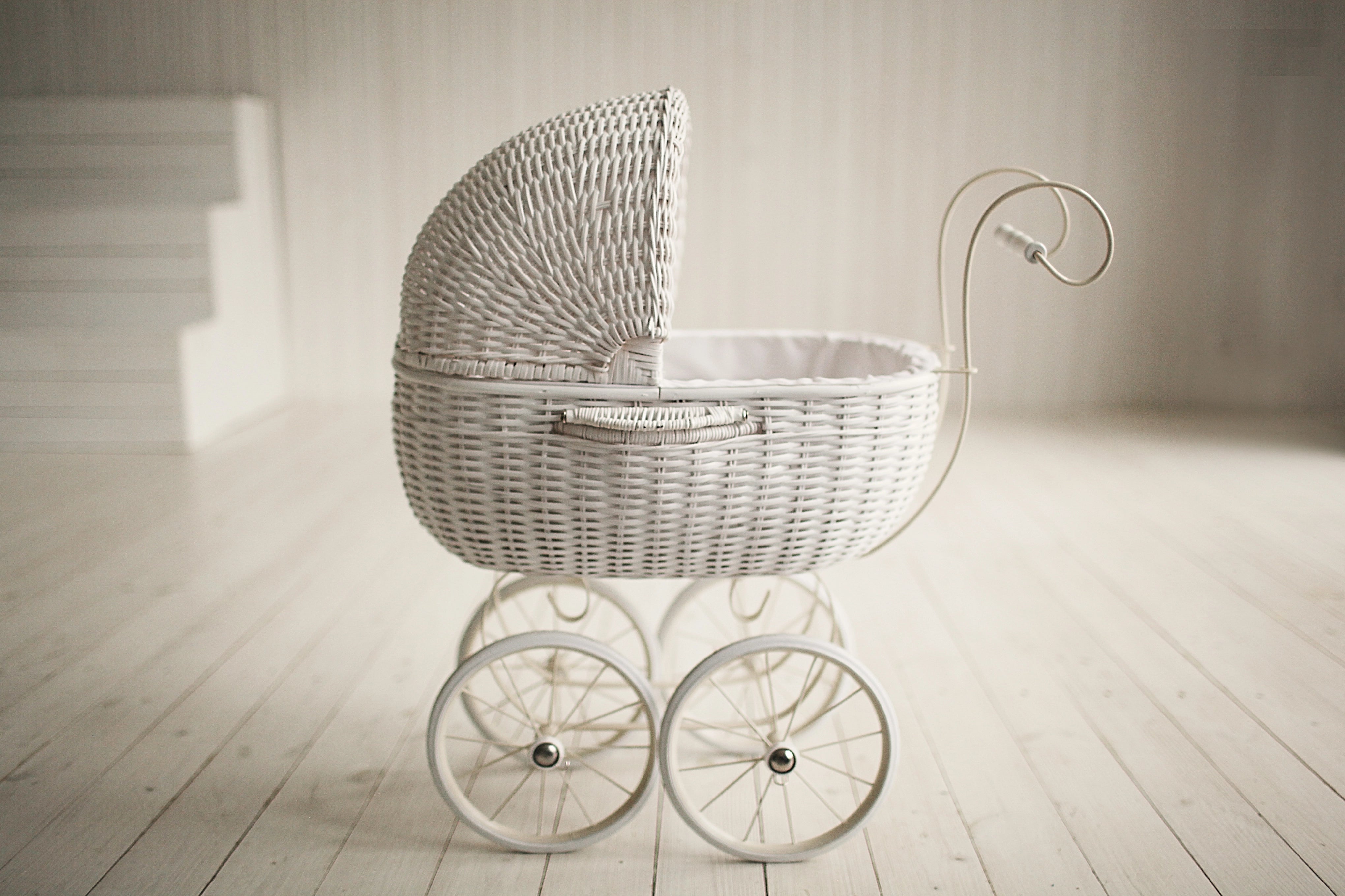 white vintage pram on timber floorboards