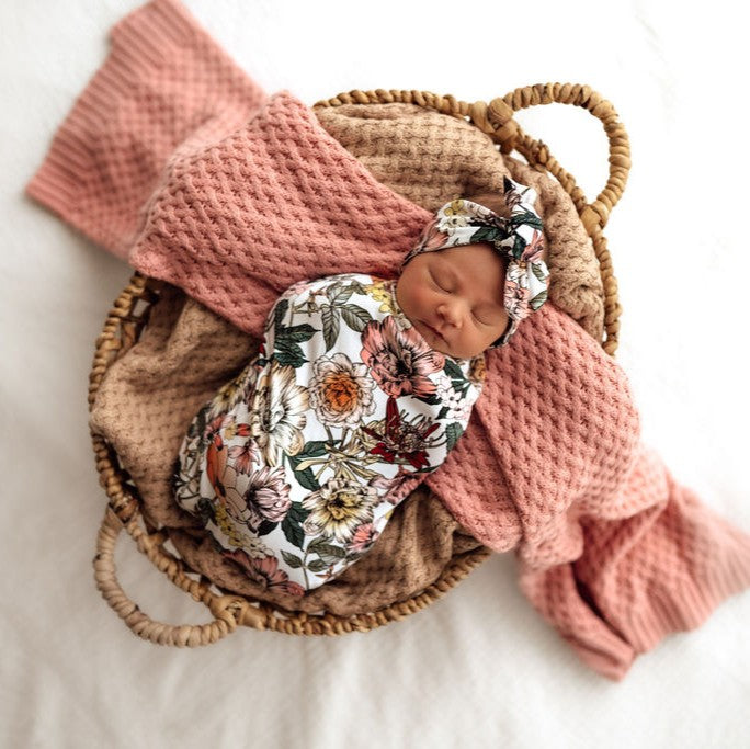 Baby sleeping in swaddle in crib