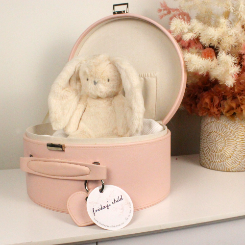 pink keepsake box open with an ivory plush bunny sitting inside with dried flower arrangement next to