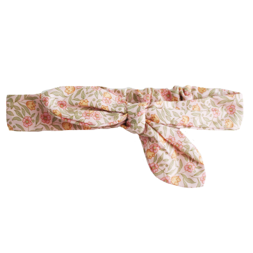 A fabric headband with a soft floral print in pink, yellow, and green on a light beige background, tied in a knot at the front.