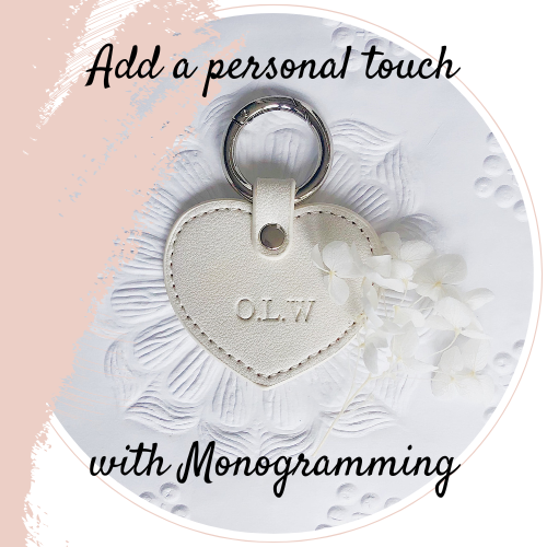 heart shaped key tag with monogrammed initials laying on a textured wallpaper