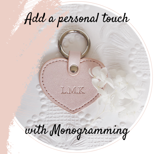 pink heart shaped tag with monogrammed initials laying on a textured wallpaper