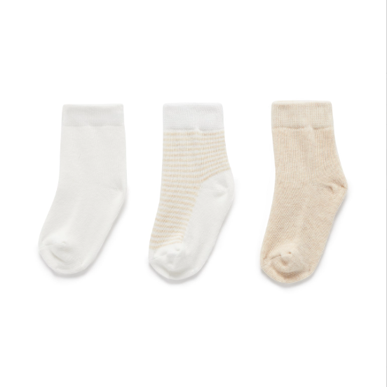 Three pairs of socks in white, beige, and cream on a white background