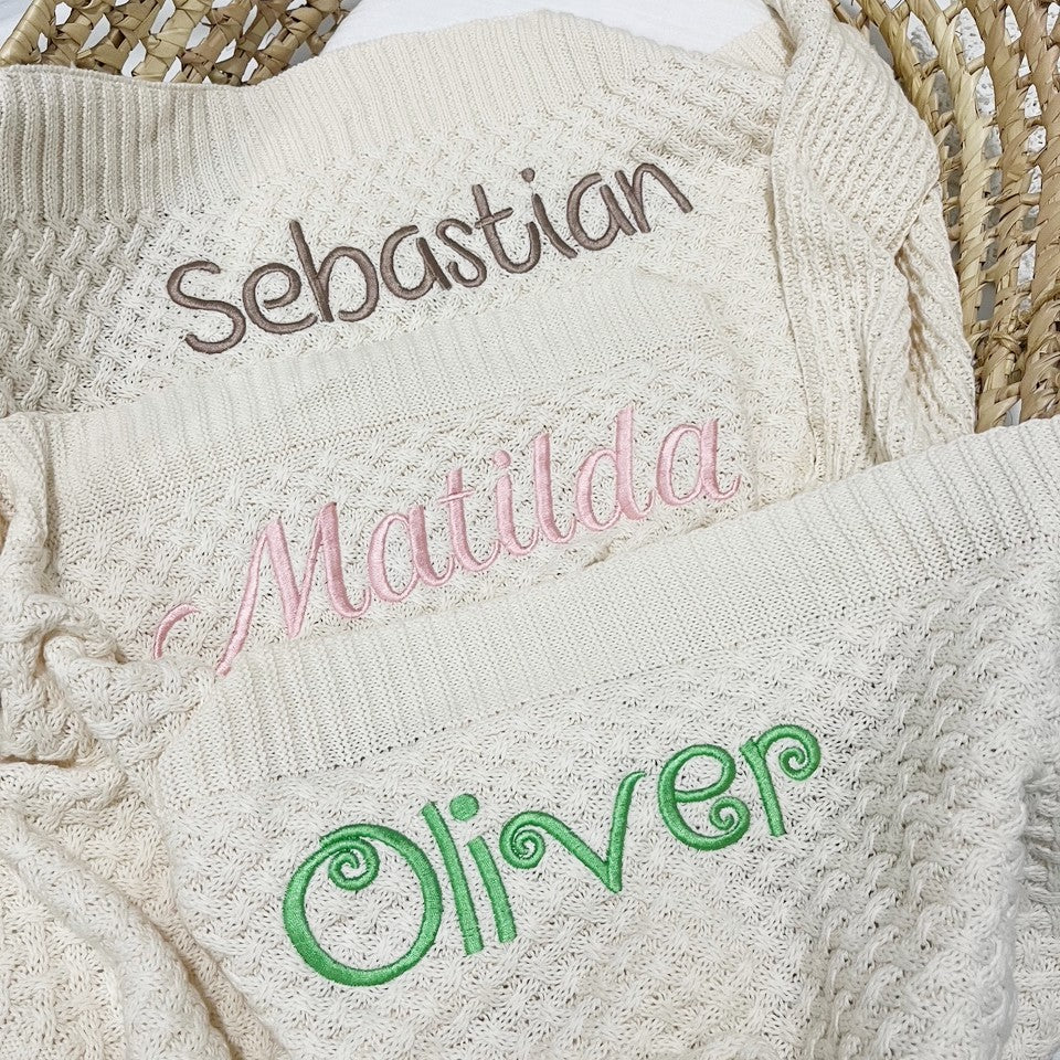 Personalised baby blankets layered in a baby bassinet