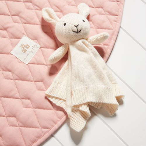 KNITTED BUNNY COMFORTER LAYING ON PINK QUILTED BLANKET