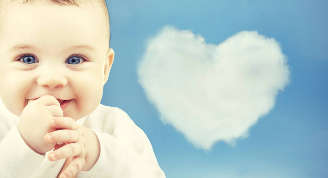 smiling baby with blue sky and heart shaped cloud