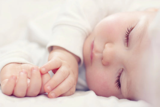 sleeping newborn baby on white blanket