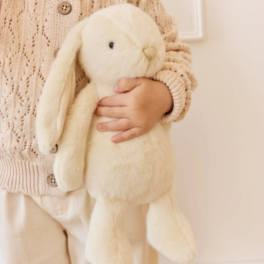 cream plush bunny in childs arms