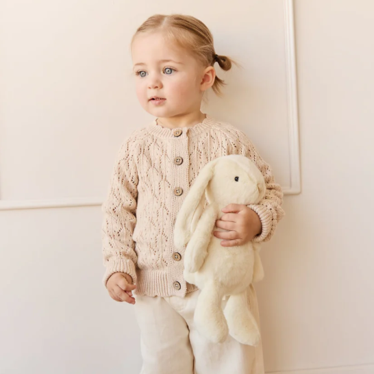 cream plush bunny toy held by child