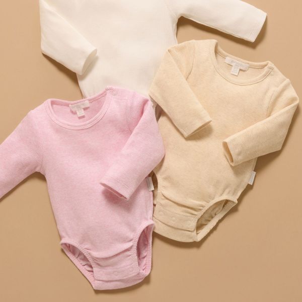 Pink and beige baby bodysuits on a beige background