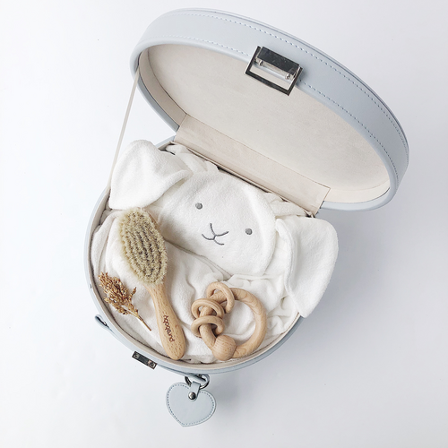 Grey keepsake box open showing bunny hooded towel, baby hair brush and wooden rattle