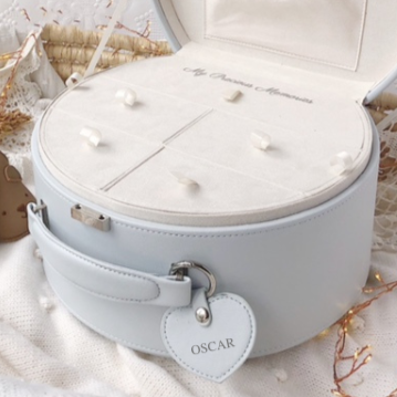 Blue-Grey keepsake box with a teddy bear inside, surrounded by decorative elements on a light background.