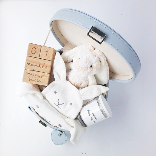 baby boy gift hamper items in a grey keepsake box, open, showing a plush toy bunny, hooded bath towel and timber milestone blocks