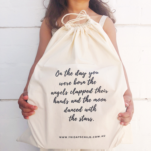 child holding a calico bag with print quote on the front