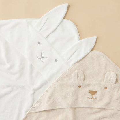 vanilla bunny hooded towel next to caramel bear hooded towel flat lay