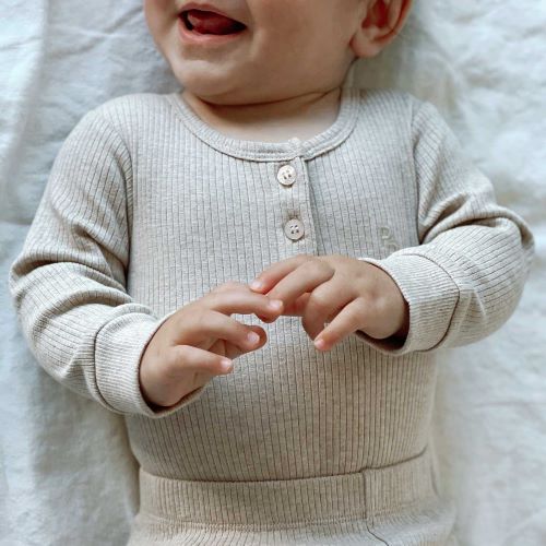 small baby dressed in ribbed body suit